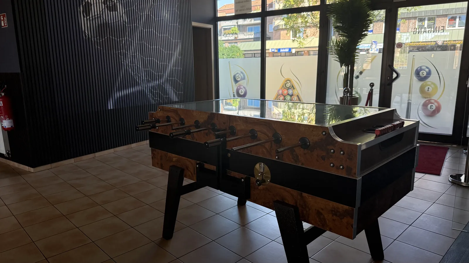 Kickertisch aus Holz mit Glasplatte am Schaufenster von Billard Voerde
