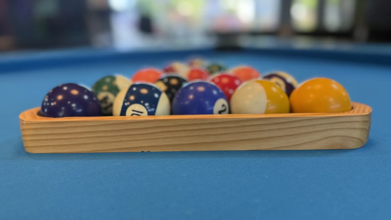 Poolkugeln im Holzdreieck auf blauem Tuch, Nahaufnahme